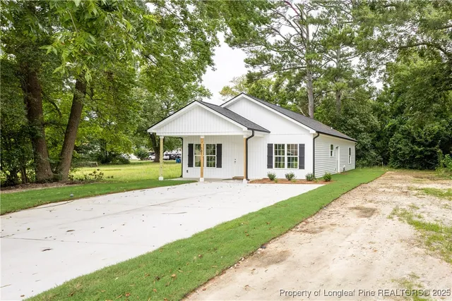 a front view of a house with a garden and yard