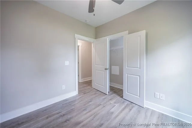 a view of a room with wooden floor and a ceiling fan