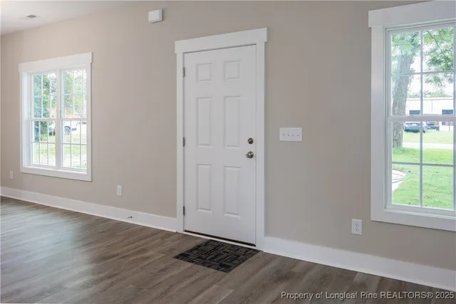 a view of an empty room and kitchen view