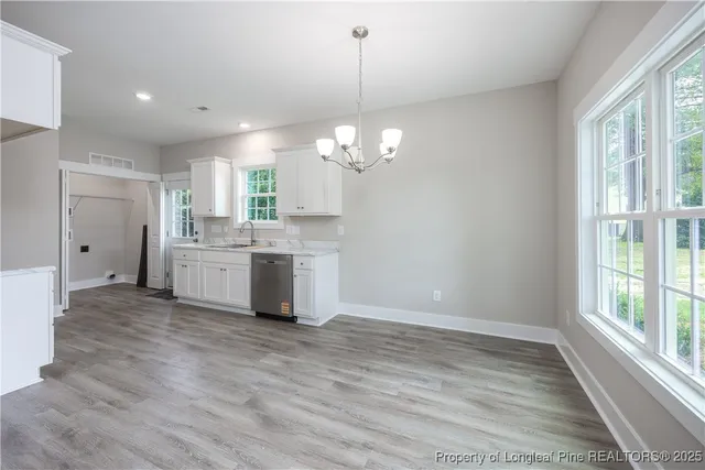 a view of a room with wooden floors and chandelier