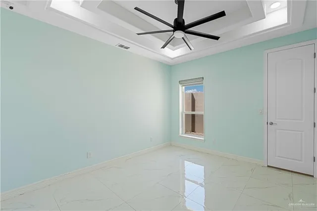 en empty room with windows and ceiling fan