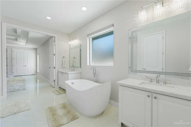 a spacious bathroom with a tub sink and mirror