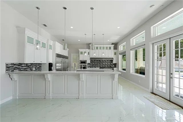 a kitchen with stainless steel appliances granite countertop a stove and white cabinets