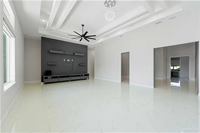 en empty room with windows and ceiling fan