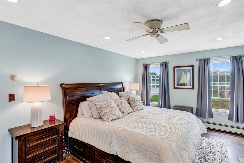 54 Old Merrill Street Amesbury, MA 01913 - Photo 18 of 34 a bedroom with a bed and a chandelier