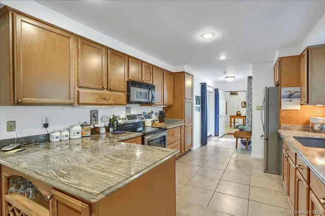 a kitchen with stainless steel appliances granite countertop a sink refrigerator and cabinets