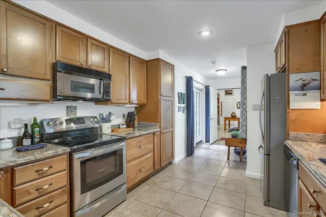 a kitchen with stainless steel appliances granite countertop wooden cabinets a stove top oven a sink and dishwasher