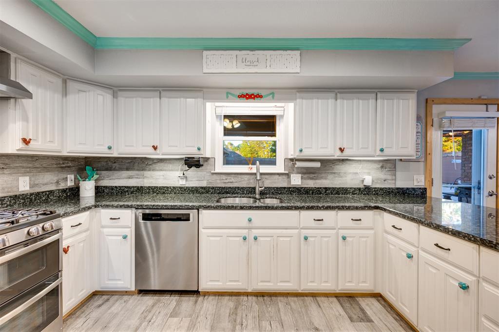 4115 Alpine Street Paris, TX 75462 - Photo 11 of 40 a kitchen with granite countertop white cabinets and a stove