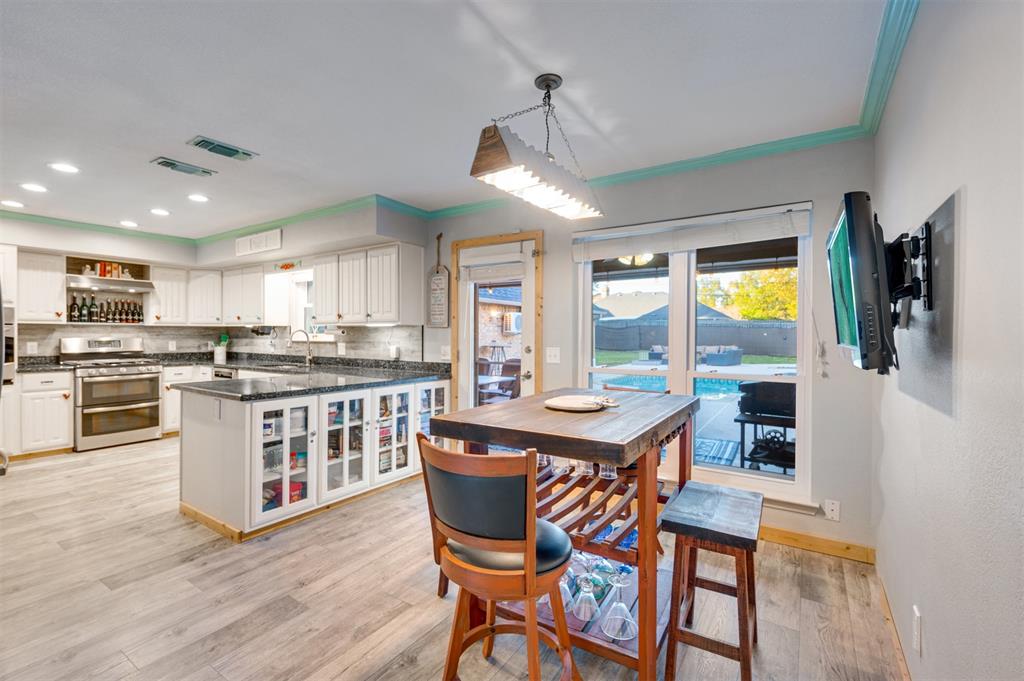 4115 Alpine Street Paris, TX 75462 - Photo 12 of 40 a kitchen with stainless steel appliances granite countertop a stove a sink a microwave a center island and a refrigerator