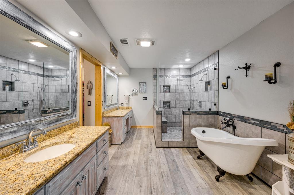 4115 Alpine Street Paris, TX 75462 - Photo 15 of 40 a spacious bathroom with a granite countertop tub sink and mirror