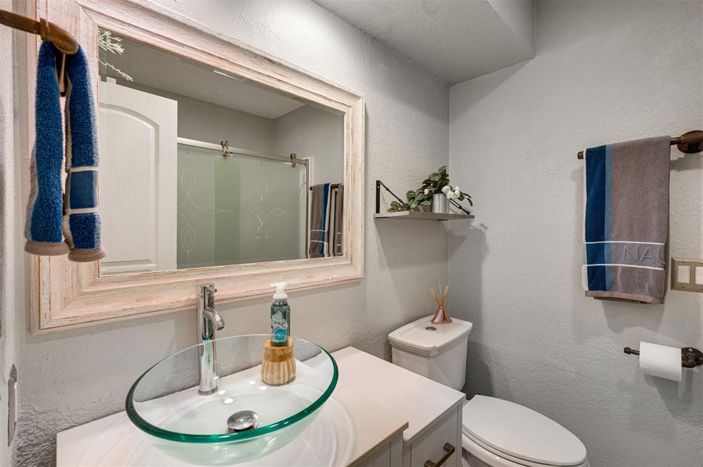 4115 Alpine Street Paris, TX 75462 - Photo 22 of 40 a bathroom with a toilet a sink and mirror