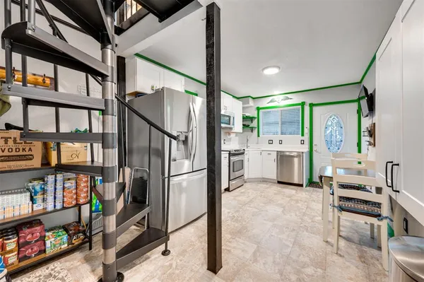 a kitchen with stainless steel appliances kitchen island granite countertop a refrigerator and cabinets
