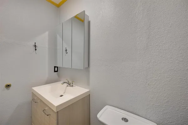 a bathroom with a toilet a sink and mirror