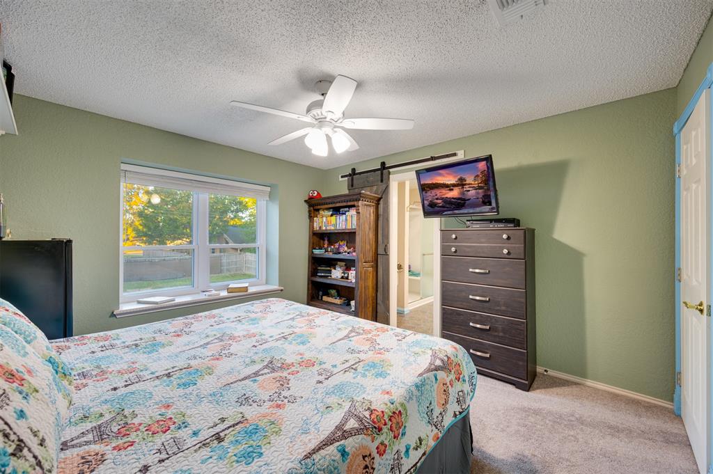 4115 Alpine Street Paris, TX 75462 - Photo 27 of 40 a bedroom with a bed and a chandelier