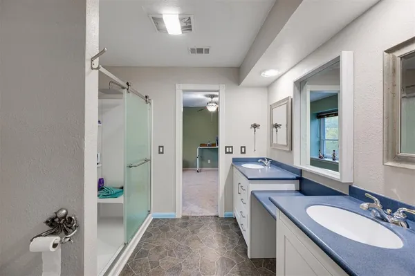 a bathroom with a granite countertop sink mirror and tub