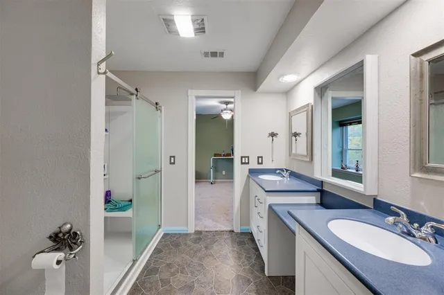 a bathroom with a granite countertop sink mirror and tub