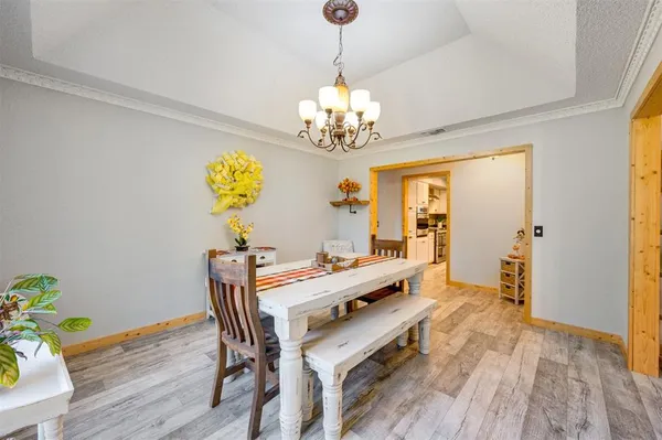 a view of a dining room with furniture a chandelier and wooden floor