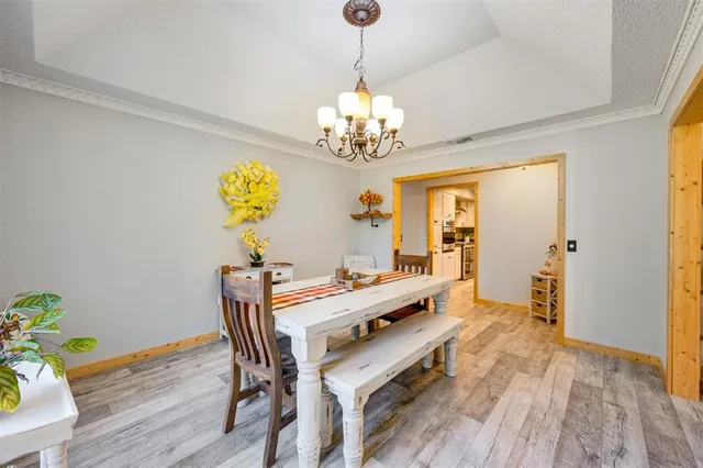 a view of a dining room with furniture a chandelier and wooden floor