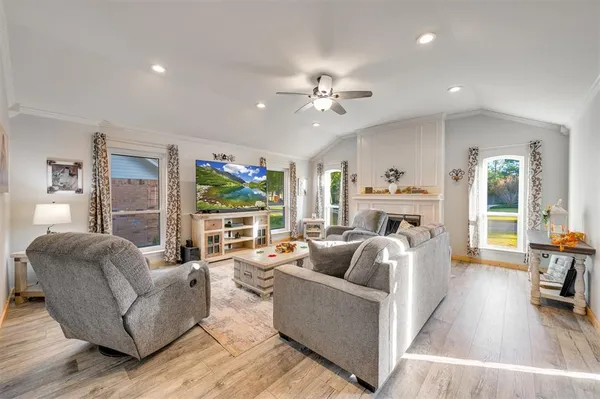 a living room with furniture fireplace and a large window