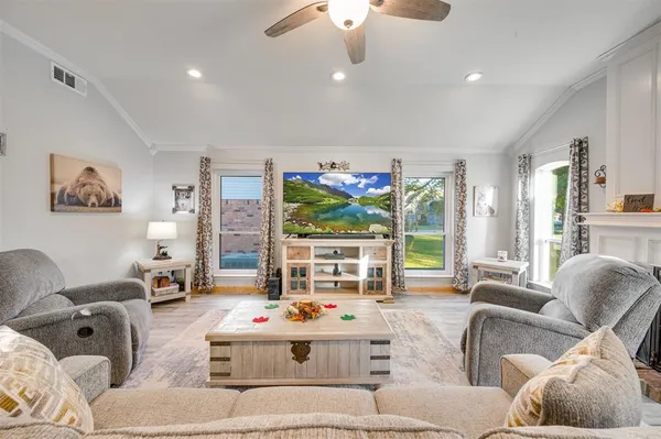 a living room with furniture fireplace and large windows