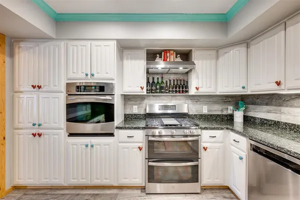 a kitchen with stainless steel appliances a stove a microwave and cabinets