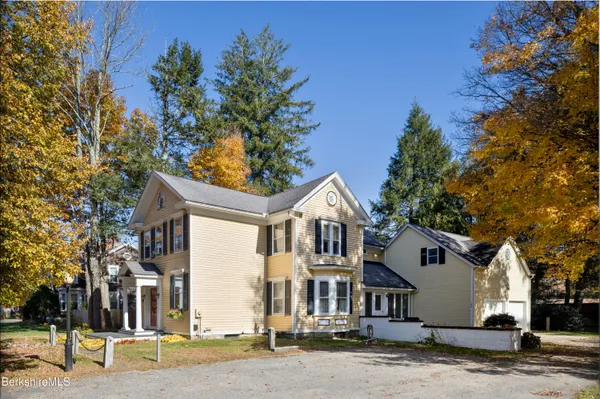 a front view of a house with a tree