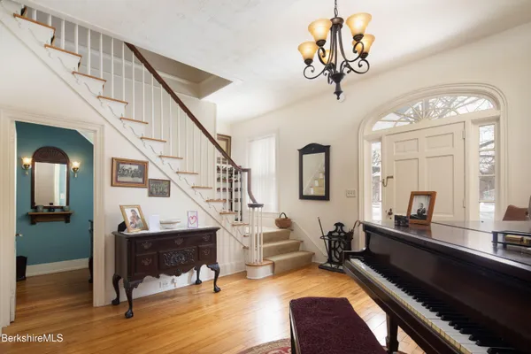 a view of hall way with furniture and a chandelier