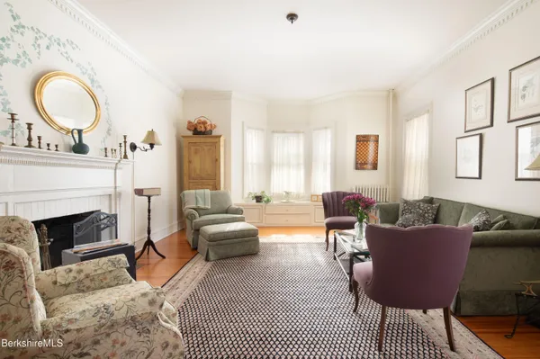 a living room with furniture a fireplace and a large window