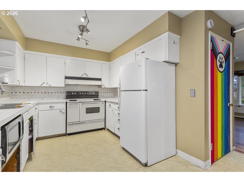 14035 Southeast Harrison Street Portland, OR 97233 - Photo 11 of 32 a kitchen with stainless steel appliances granite countertop a refrigerator and a stove top oven