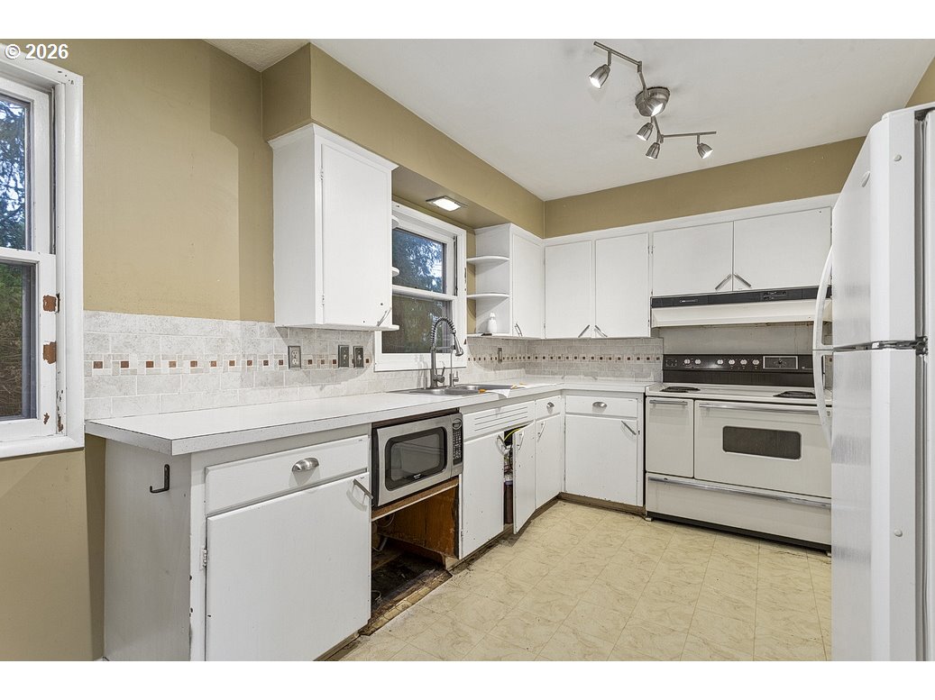 14035 Southeast Harrison Street Portland, OR 97233 - Photo 12 of 32 a kitchen with a sink stove and cabinets