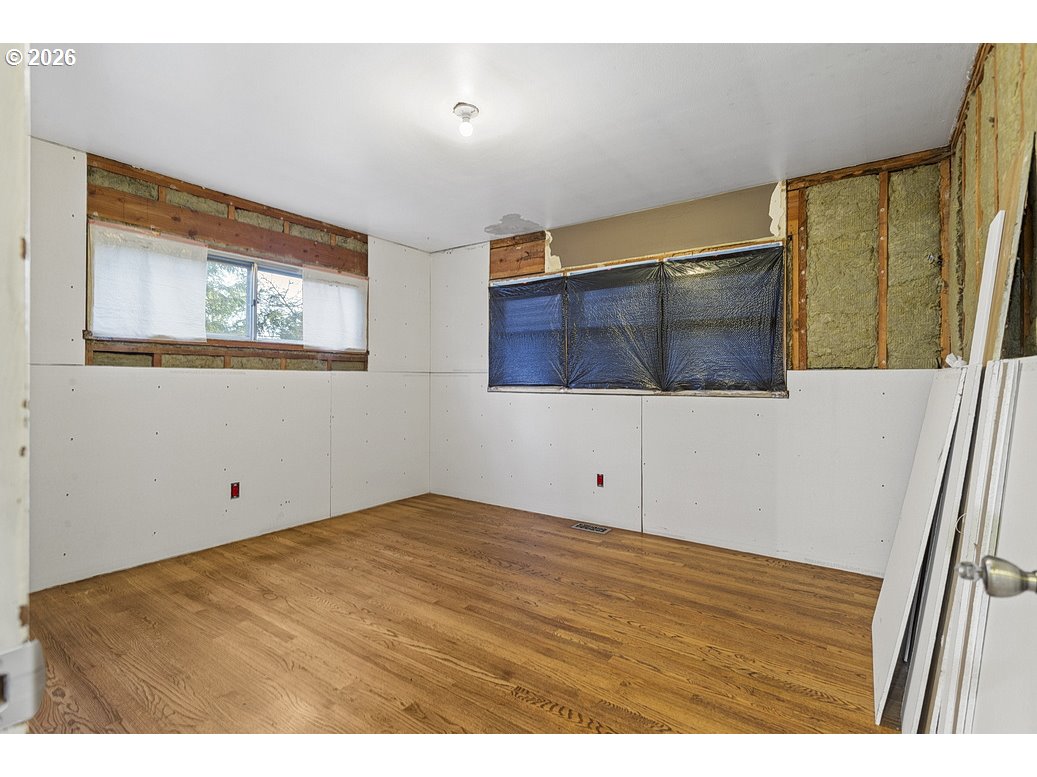 14035 Southeast Harrison Street Portland, OR 97233 - Photo 17 of 32 a view of an empty room with wooden floor and a window