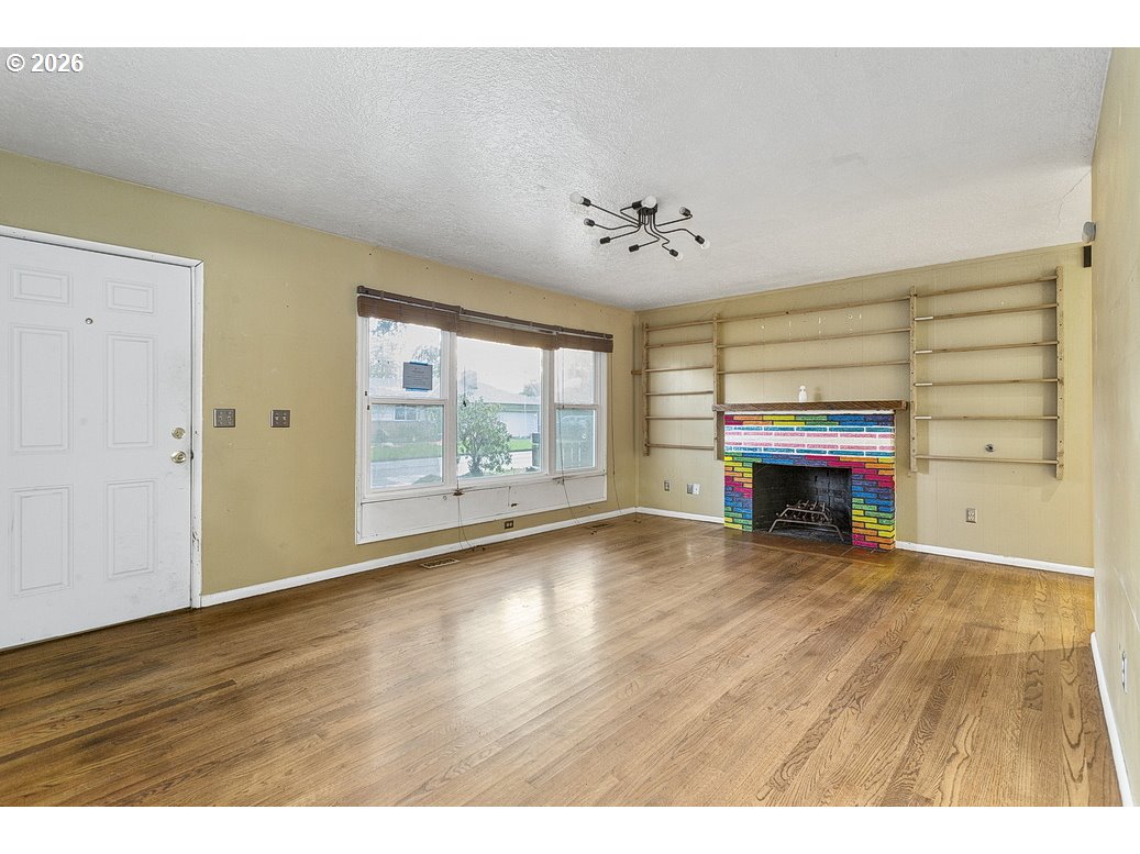 14035 Southeast Harrison Street Portland, OR 97233 - Photo 3 of 32 a view of an empty room with wooden floor and a window