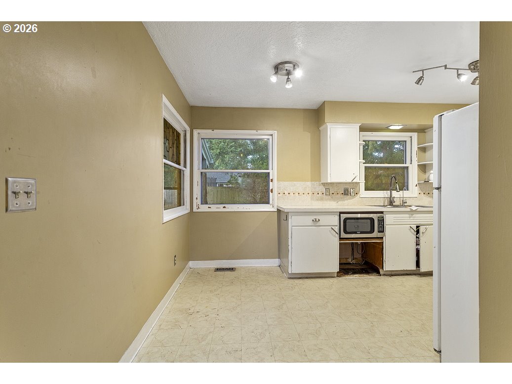 14035 Southeast Harrison Street Portland, OR 97233 - Photo 8 of 32 a kitchen with a stove a sink and a refrigerator