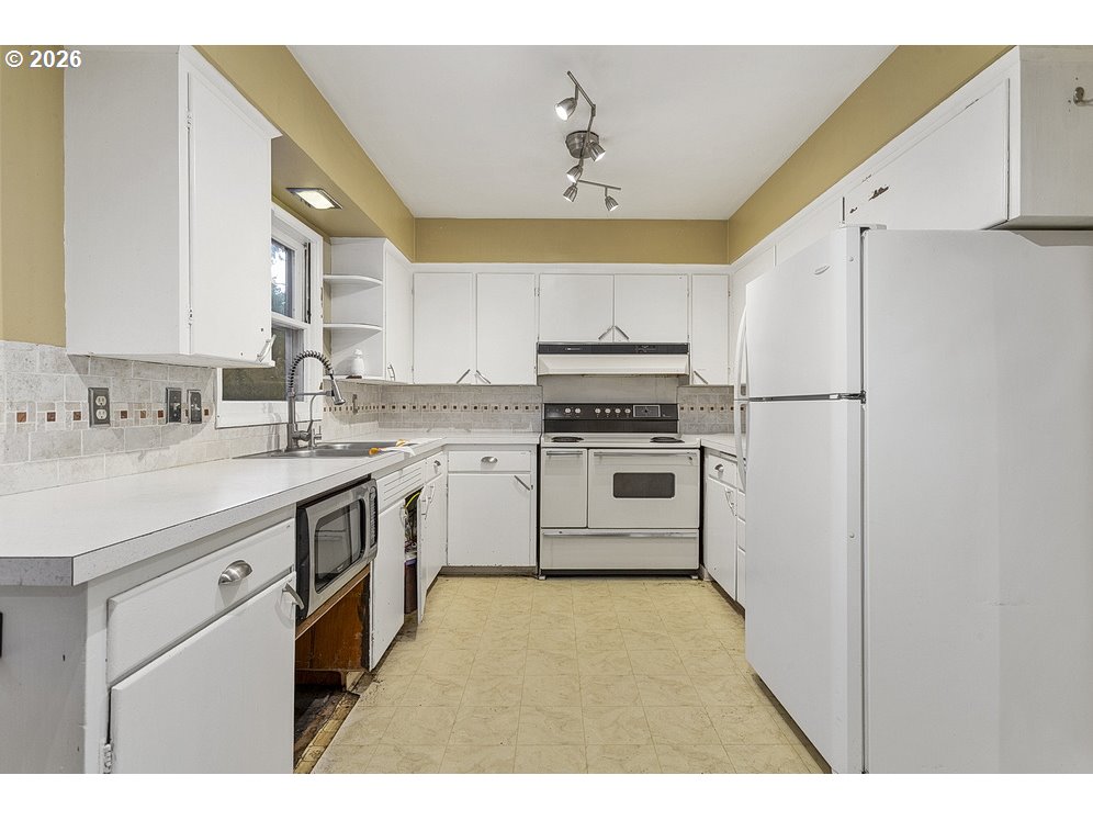 14035 Southeast Harrison Street Portland, OR 97233 - Photo 10 of 32 a kitchen with a sink appliances and cabinets