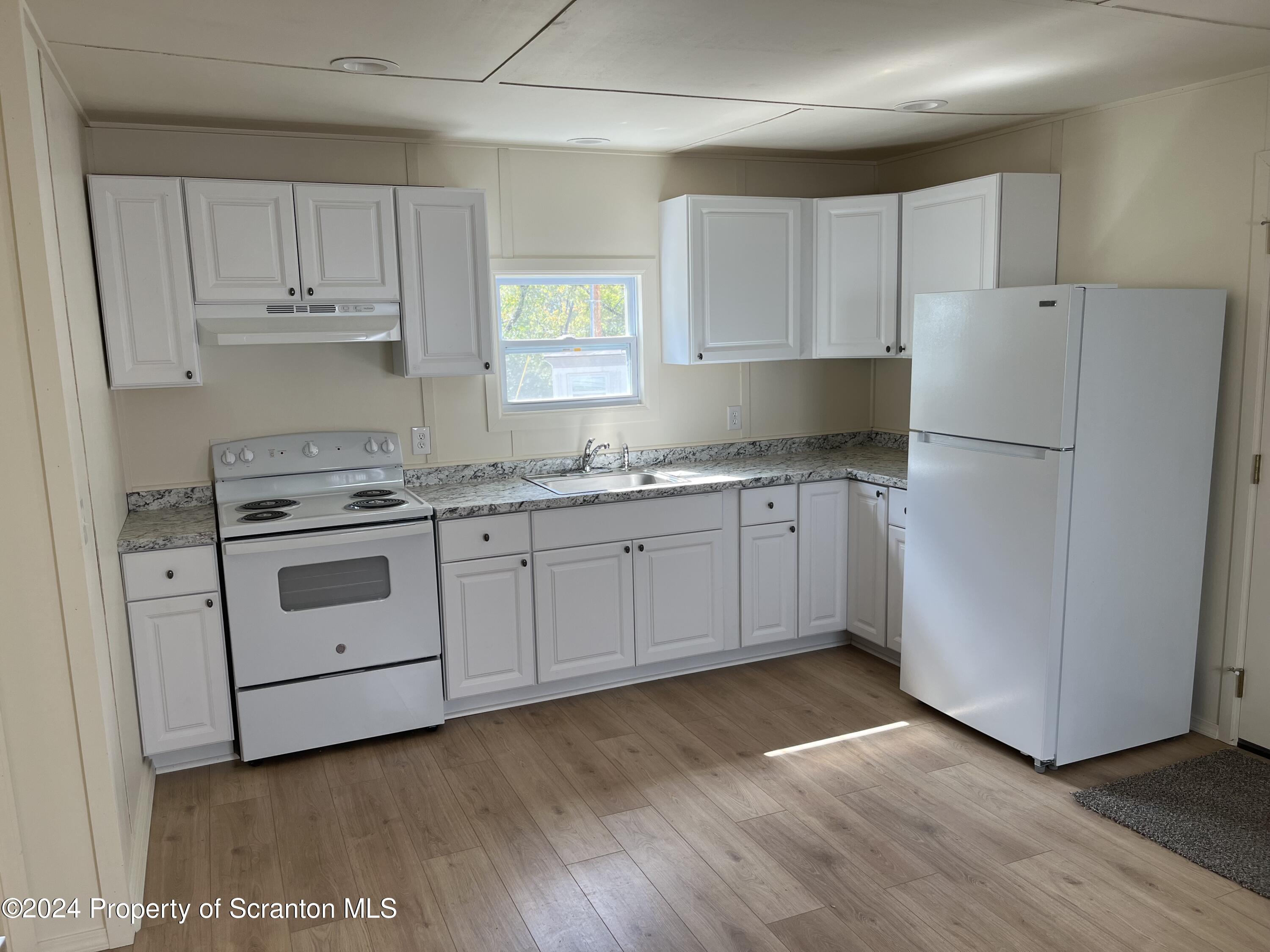 64 Franklin Street Great Bend, PA 18821 - Photo 25 of 33 a kitchen with granite countertop white cabinets and white appliances