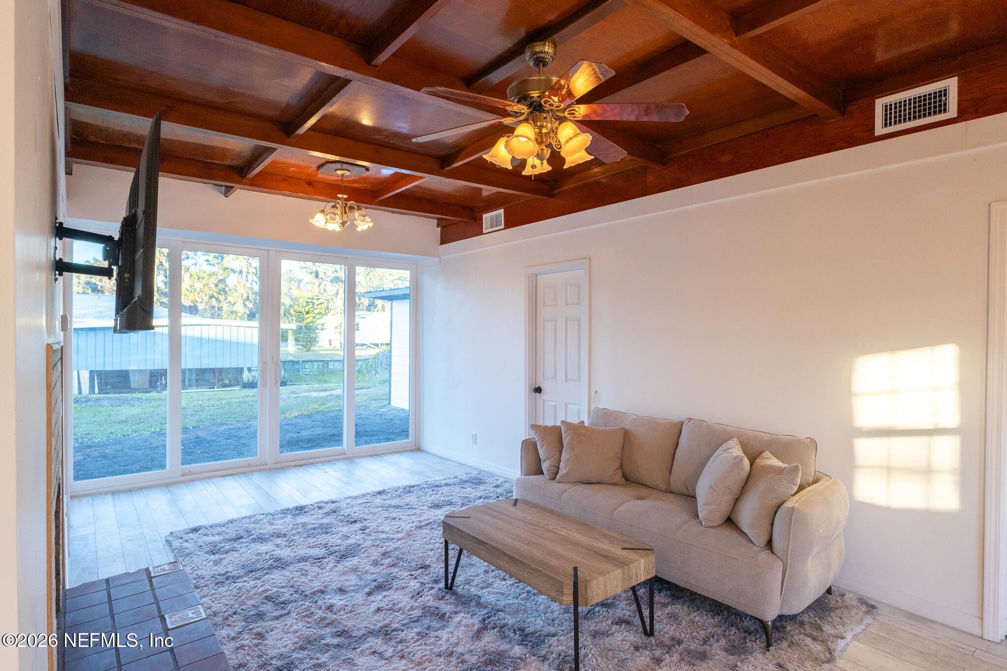 110 Jimmie Road Crescent City, FL 32112 - Photo 6 of 54 a living room with furniture a chandelier and a floor to ceiling window