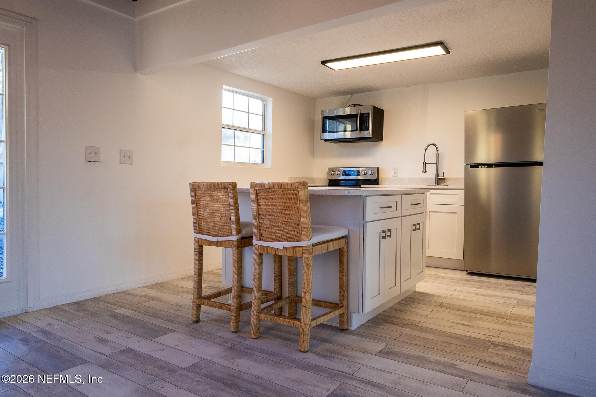 110 Jimmie Road Crescent City, FL 32112 - Photo 10 of 54 a kitchen with stainless steel appliances a stove a sink refrigerator and white cabinets with wooden floor