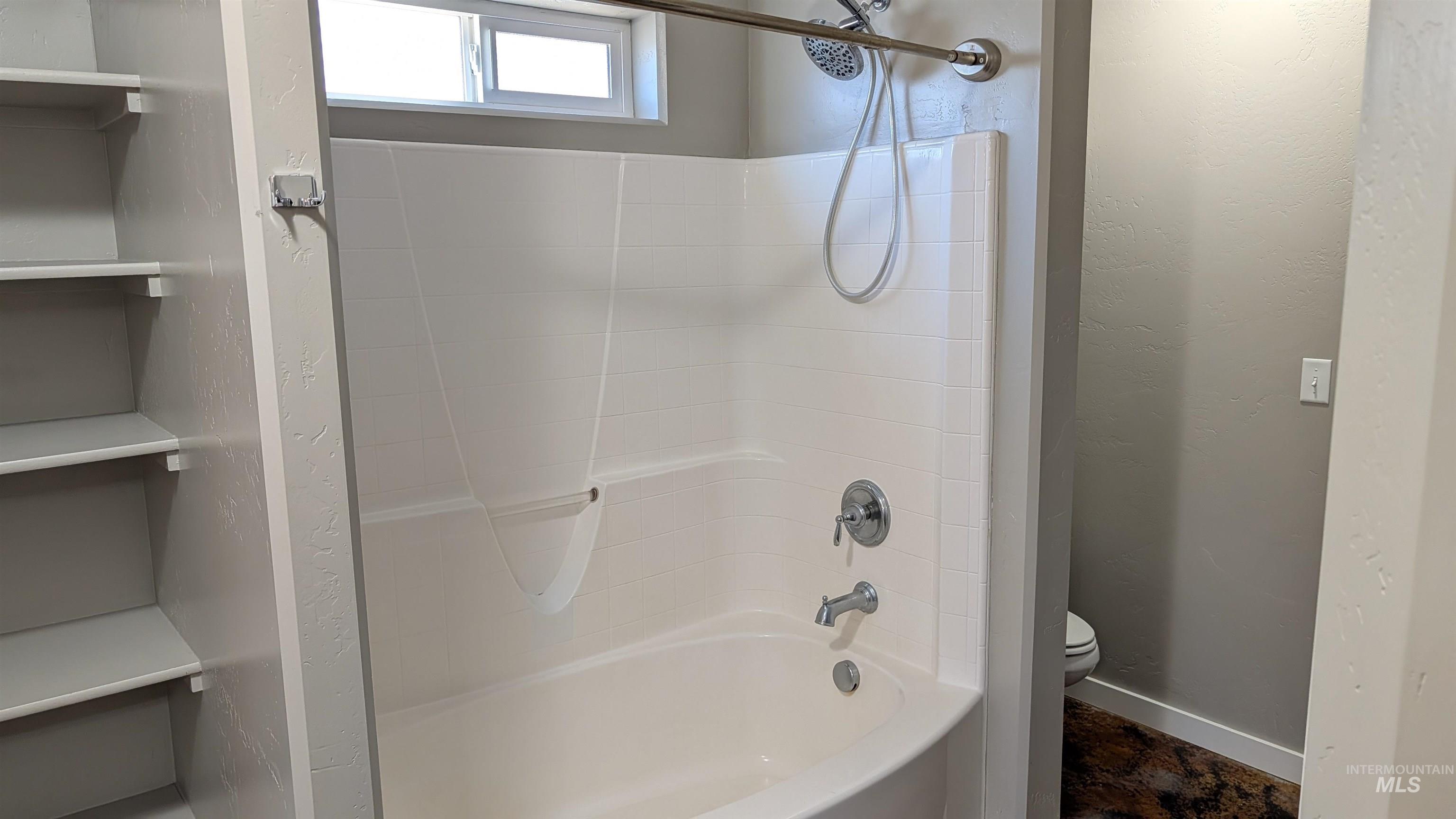 622 Lochsa Loop Heyburn, ID 83336 - Photo 11 of 17 Tub and shower combination featuring a curved white basin, chrome fixtures, and a handheld showerhead