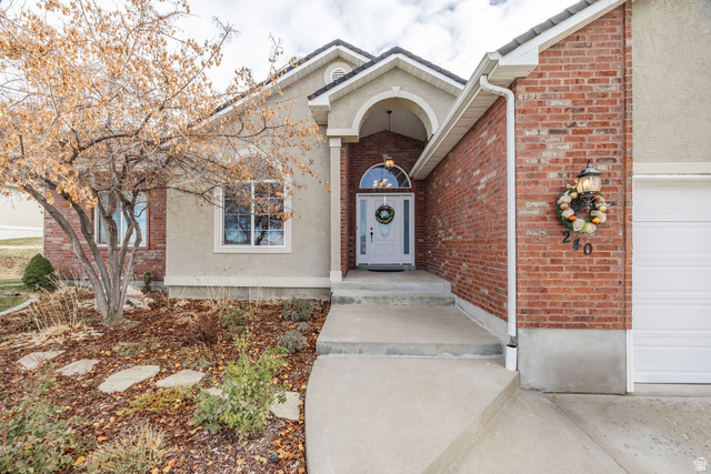 240 Bugle Way Providence, UT 84332 - Photo 3 of 15 Entryway featuring an arched portico, a white front door with an arched transom, and a concrete pathway