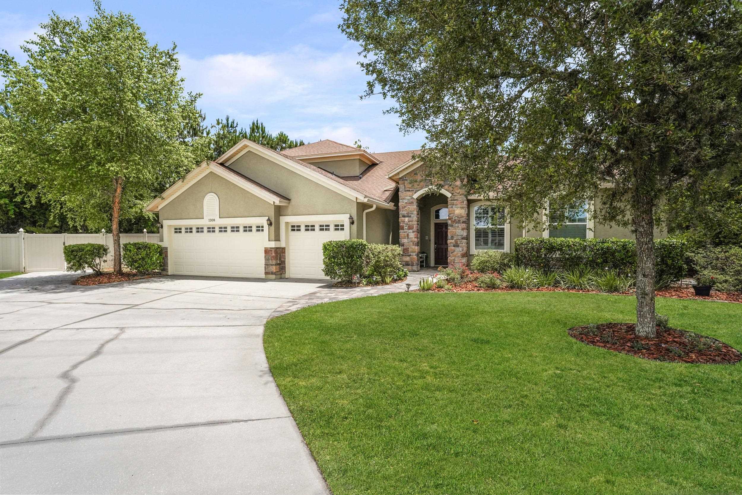 1308 Acorn Ridge Court St. Augustine, FL 32092 - Photo 1 of 47 a front view of a house with a garden and trees