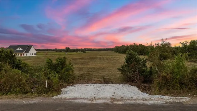 a view of a lake with sunset in the background