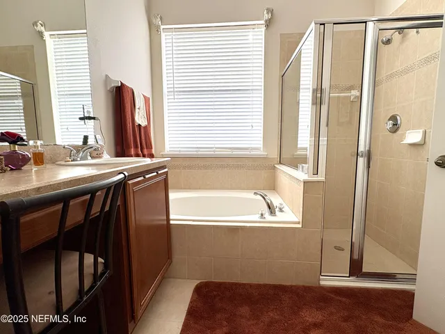 a bathroom with a tub sink and mirror