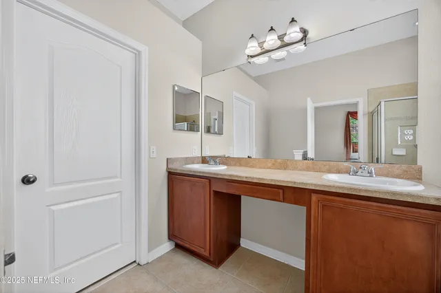 a spacious bathroom with a double vanity sink and a mirror