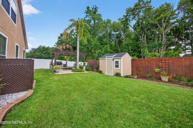 a view of a backyard with table and chairs and wooden fence