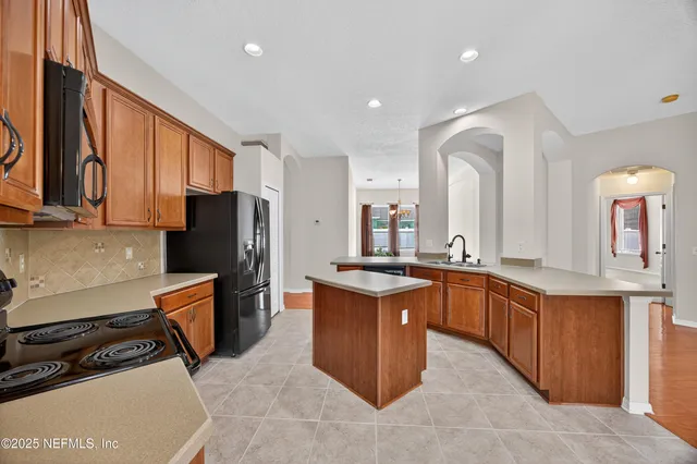 a kitchen with stainless steel appliances granite countertop a stove a sink dishwasher and a refrigerator