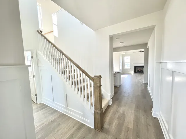 a view of a hallway with wooden floor and staircase