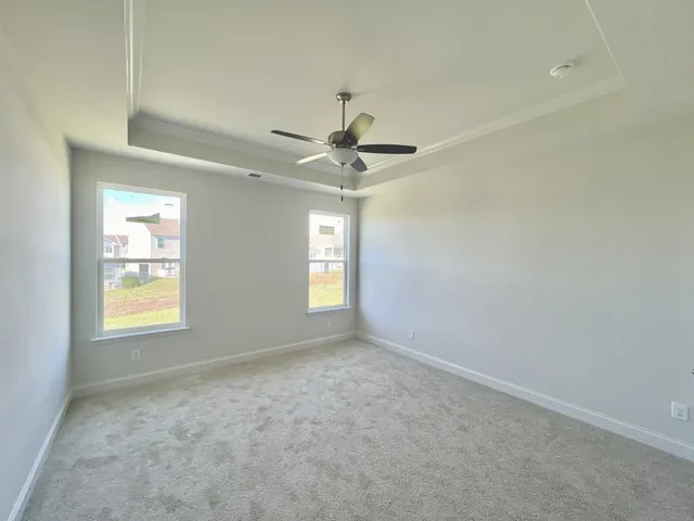 en empty room with windows and ceiling fan