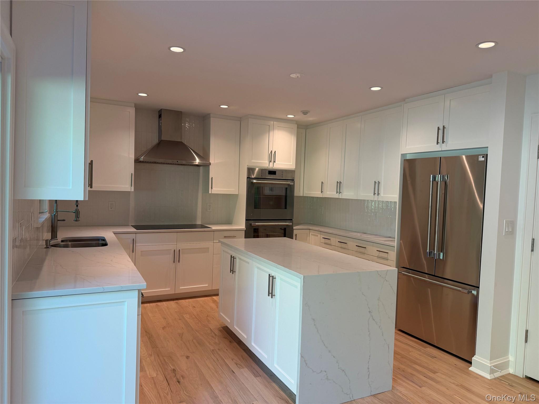 24 Country Road Mamaroneck, NY 10543 - Photo 5 of 37 a kitchen with a sink a refrigerator and a stove top oven with wooden floor