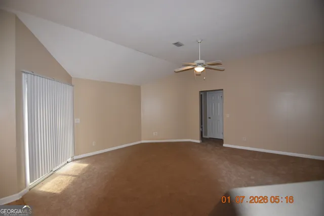 a view of an empty room with a ceiling fan