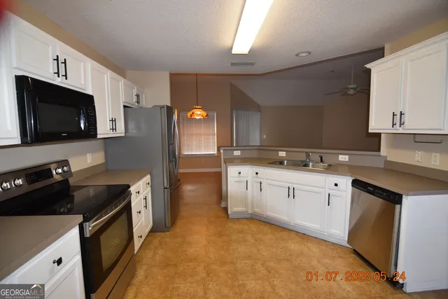 a kitchen with granite countertop a sink stove and refrigerator